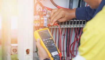 Workers use a Multimeter to measure the voltage of electrical wires produced from solar energy to confirm systems working normally